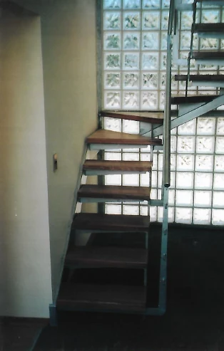 Escalera estructura metalica y pared ladrillos de vidrio.